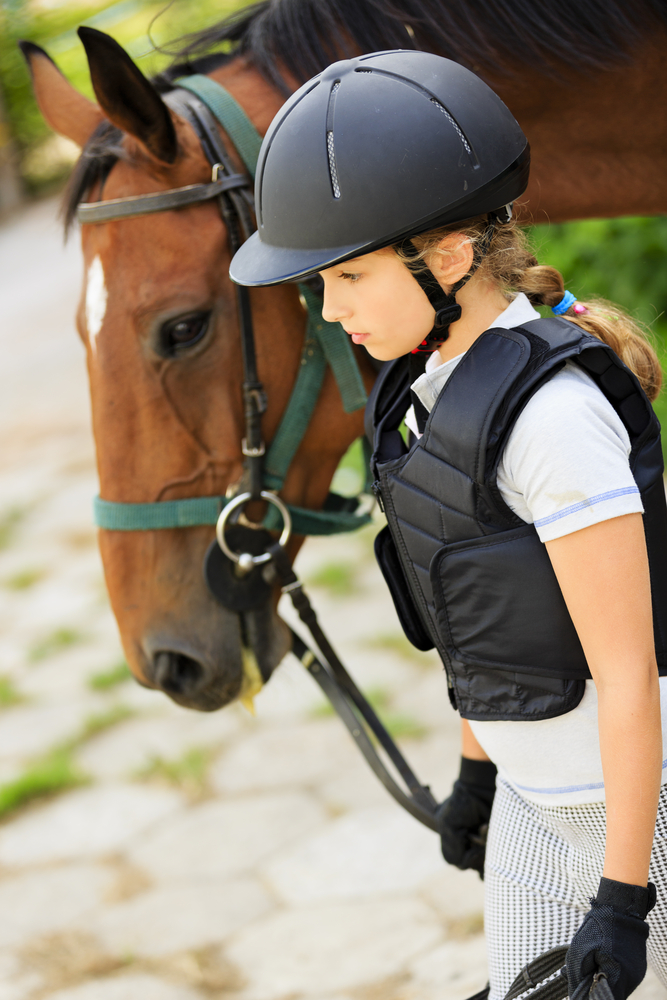 Horse and lovely equestrian girl A young equestrian leads her horse.