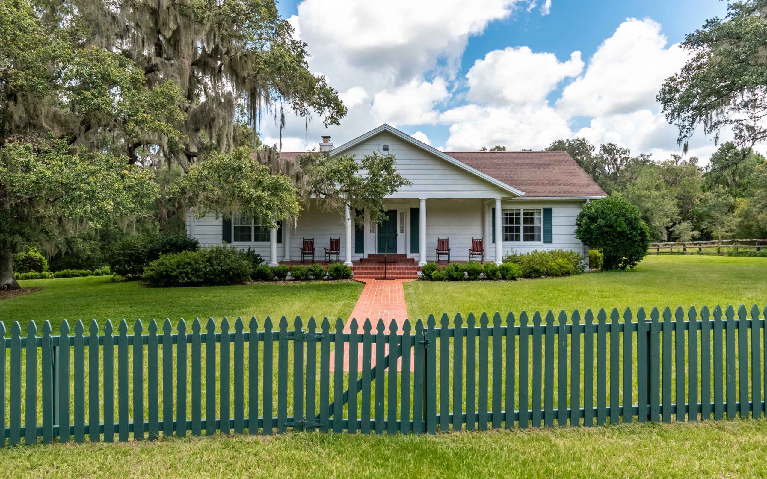 59 One of the beautiful homes located at Bopodo Farm - A white home surrounded by a green picket fence.