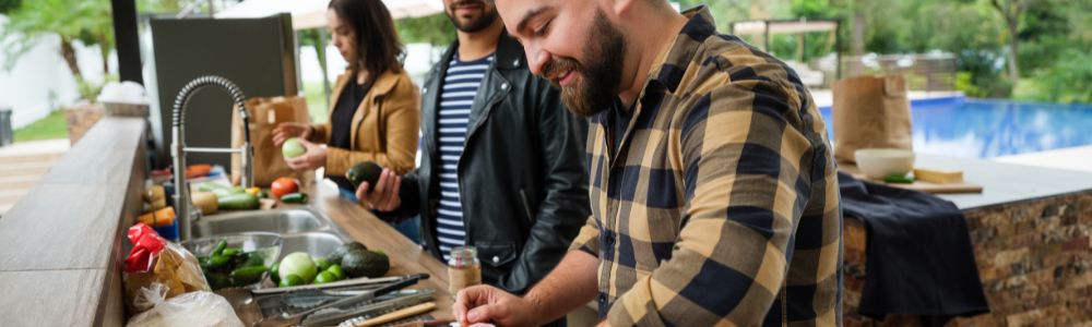 Friends cooking together in an outdoor kitchen